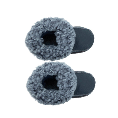 Handgjorda marinblå fårskinnstofflor för barn, visade uppifrån på vit bakgrund