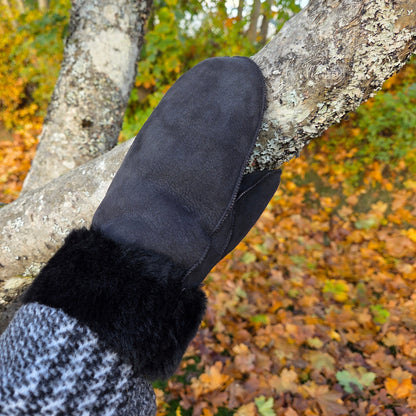 andgjorda svarta fårskinnsvantar från Jakob’s Handmade – fotograferade i höstmiljö, där värmen möter naturen.