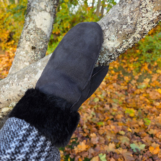 andgjorda svarta fårskinnsvantar från Jakob’s Handmade – fotograferade i höstmiljö, där värmen möter naturen.
