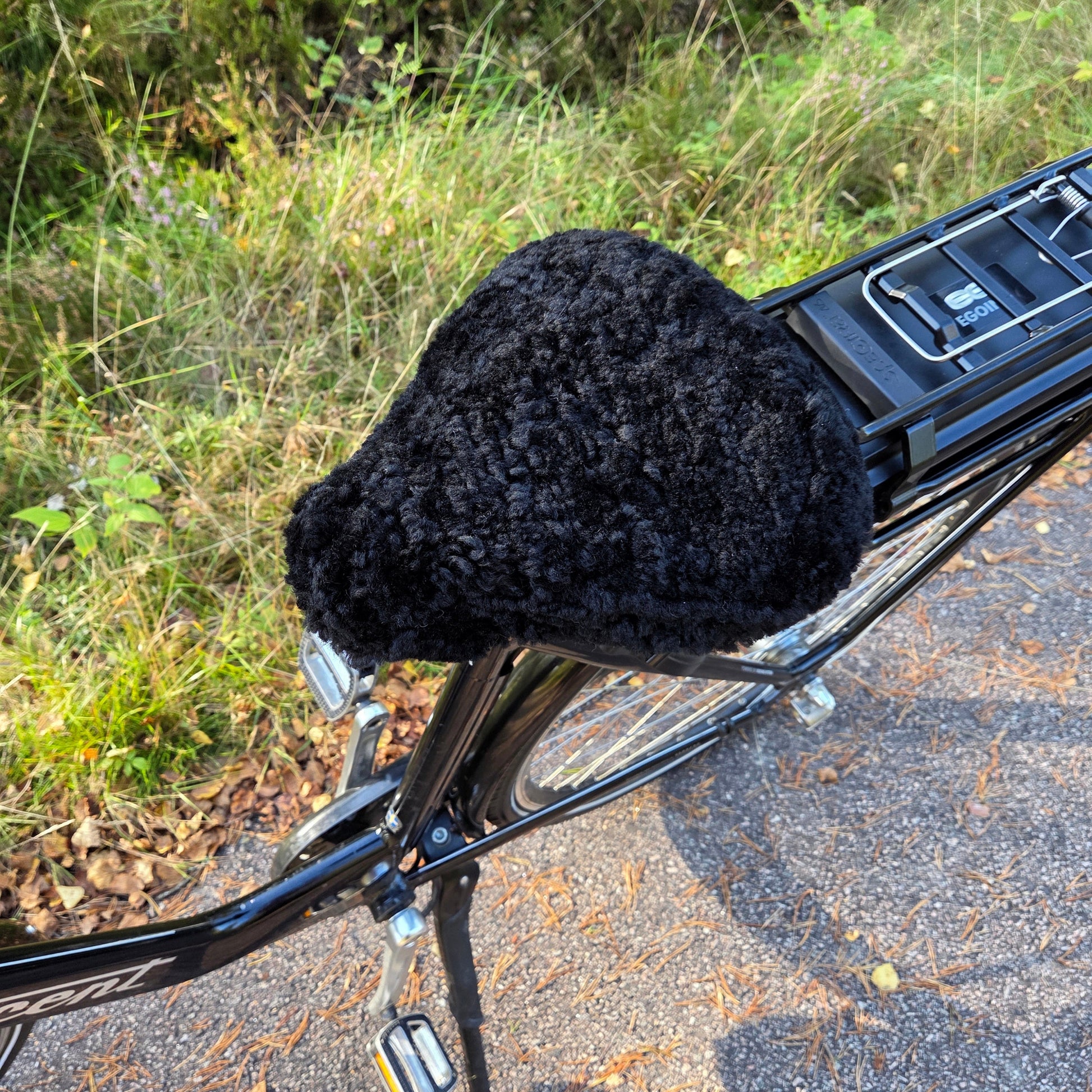 Cykelsadelskydd i svart fårskinn som ger komfort, värme och skydd till cykelsadeln