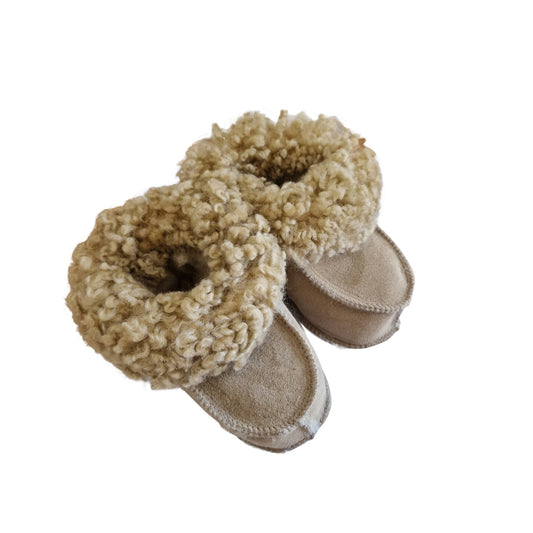 Handgjorda Beigefärgade fårskinnstofflor för baby med naturlig lockig ullkant från Jakobs Handmade – mjuka och ekologiska.