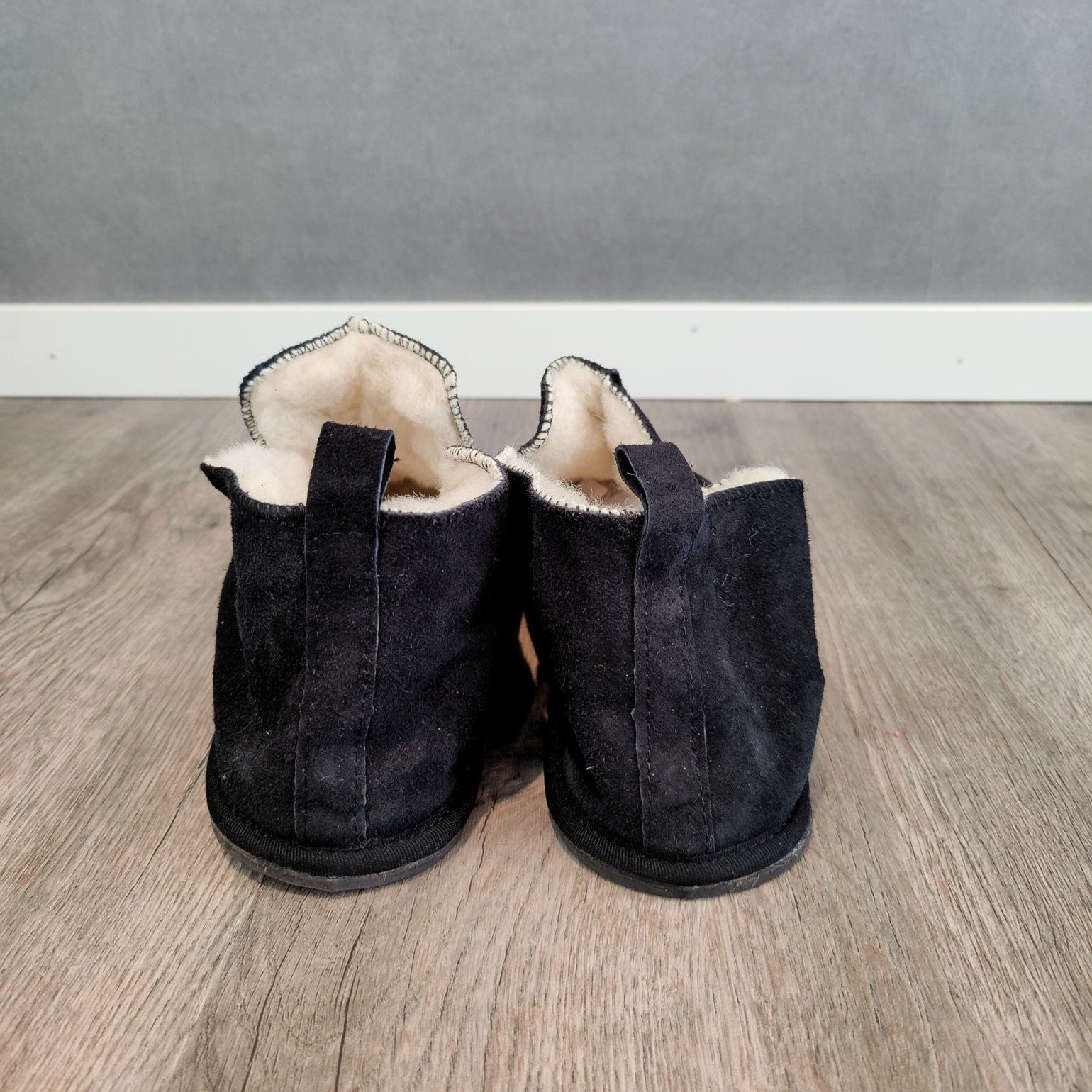 Baksida av svarta Kosmos merinoullstofflor från Jakobs Handmade – varma tofflor i mocka och merinoull med slitstark sula och smart ögla för enkel påtagning.